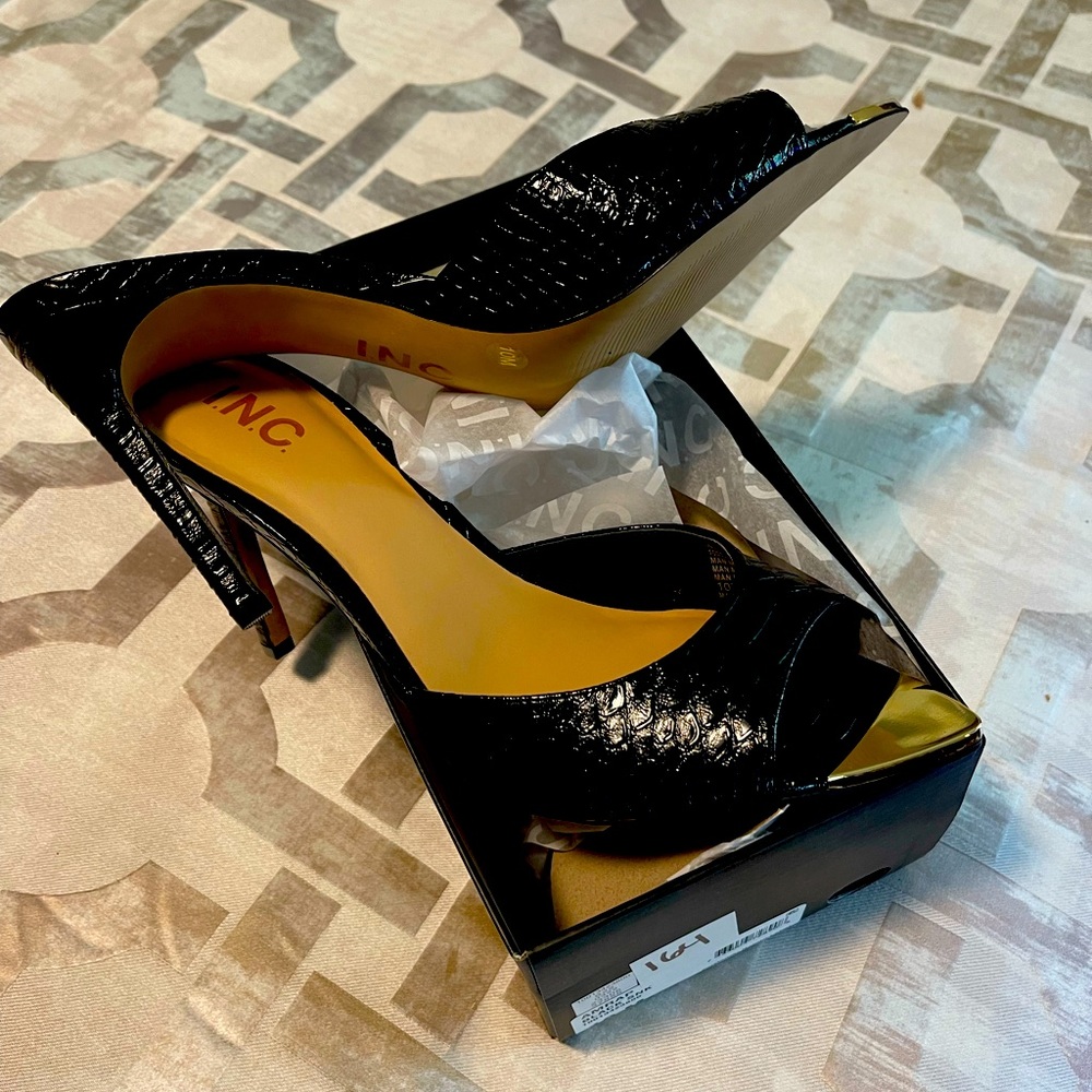 Black slides with goldtone toe detail.